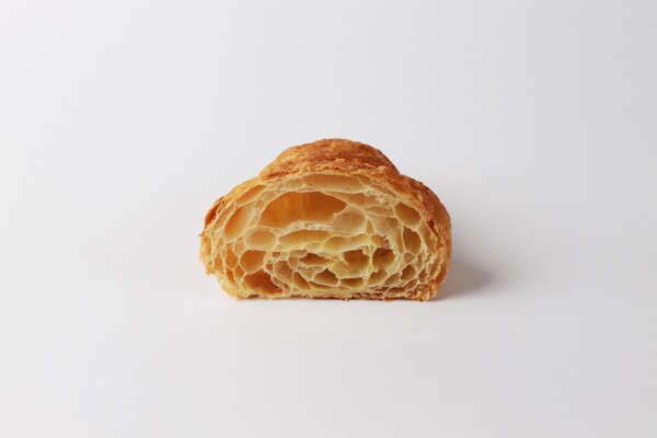 Croissant droit beurre coupé en deux, une viennoiserie feuilletée et croustillante au beurre, parfaite pour accompagner votre café ou pour une pause sucrée.