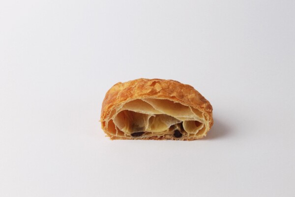 Pain au chocolat beurre coupé en deux, une viennoiserie feuilletée et chocolatée au beurre, parfaite pour une pause gourmande.