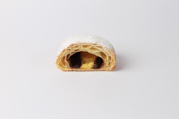 Pain au chocolat crème beurre coupé en deux, une viennoiserie feuilletée et chocolatée à la crème et au beurre, parfaite pour une pause gourmande.