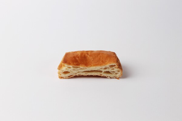 Couque carré coupée en deux, une pâtisserie feuilletée et croustillante, parfaite pour accompagner votre café ou pour une pause sucrée.