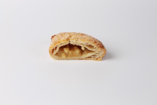 Gosette pomme coupée en deux, une pâtisserie feuilletée fourrée aux pommes fondantes, idéale pour une pause gourmand.