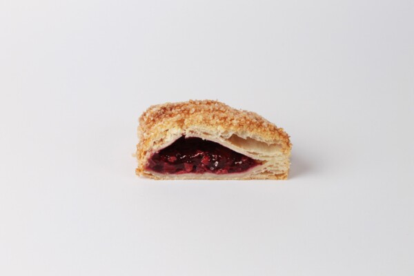 Gosette cerise coupée en deux, une délicieuse pâtisserie feuilletée fourrée aux cerises, parfaite pour une pause sucrée.