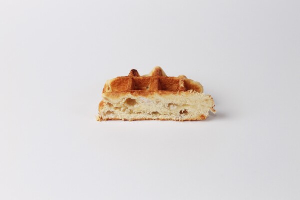 Gaufre Liégeoise sucrée au beurre coupée en deux, délicieuse spécialité belge servie chaude avec une texture moelleuse à l'intérieur et croustillante à l'extérieur.