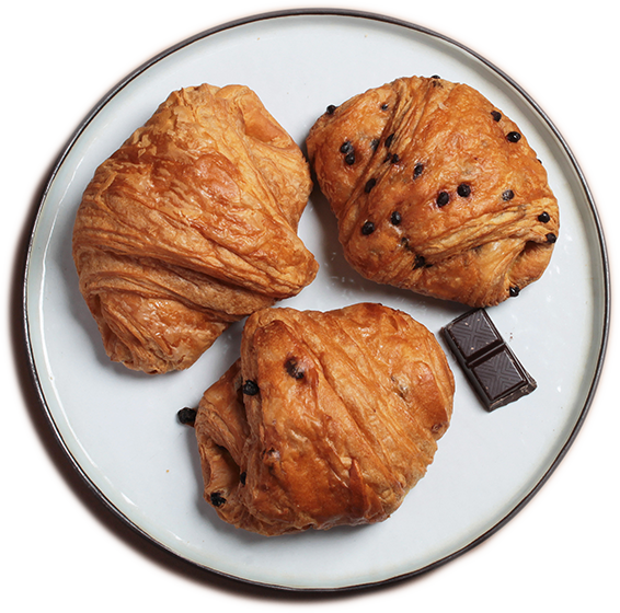 Assiette de viennoiseries : deux couques au beurre avec pépites de chocolat, une couque au beurre nature et un petit morceau de chocolat.